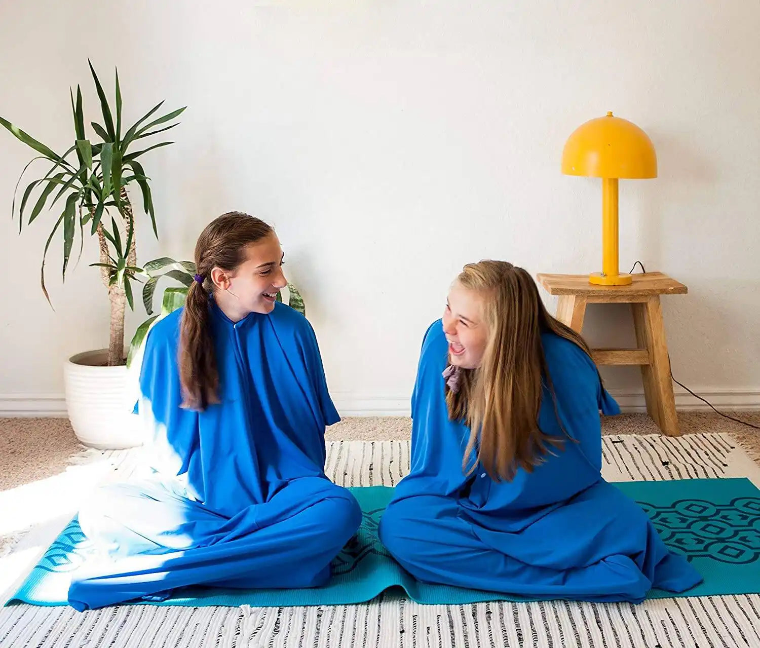 Two girls wearing blue wearable blanket pajamas.
